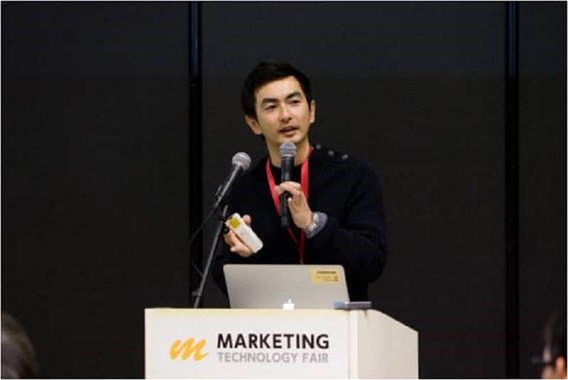 登壇するシバタアキラ氏。